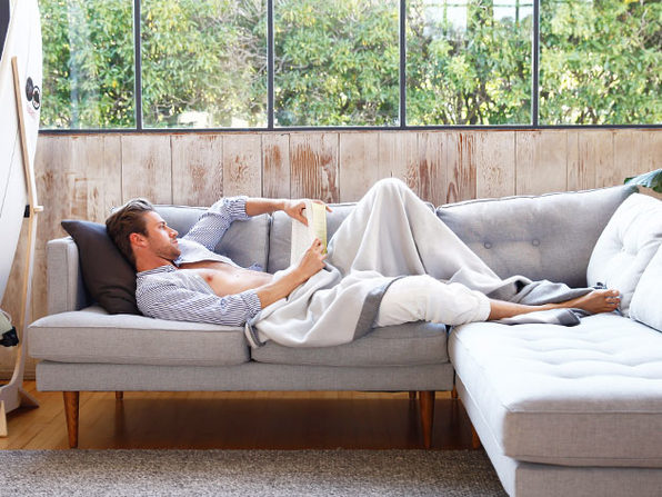 Resting on the sofa with an infinity blanket reading a book